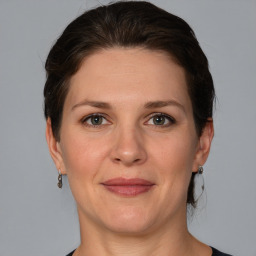 Joyful white adult female with medium  brown hair and grey eyes