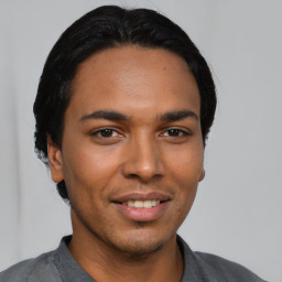 Joyful latino young-adult male with short  black hair and brown eyes