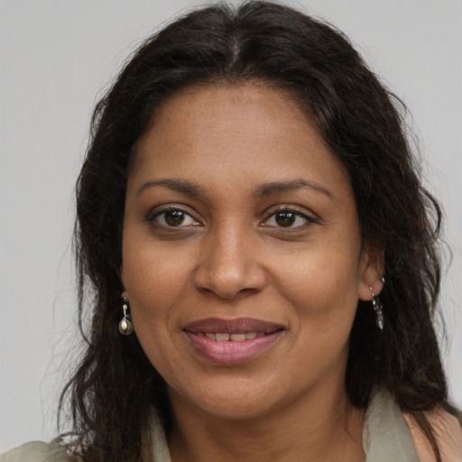 Joyful black adult female with long  brown hair and brown eyes