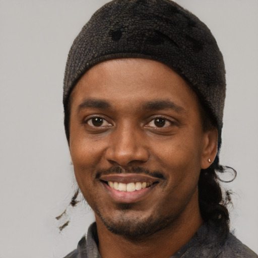Joyful black young-adult male with short  black hair and brown eyes