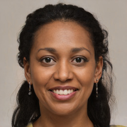 Joyful black young-adult female with long  brown hair and brown eyes