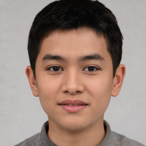 Joyful asian child male with short  brown hair and brown eyes