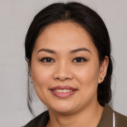 Joyful latino young-adult female with medium  brown hair and brown eyes