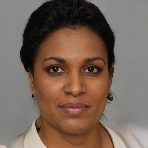 Joyful black young-adult female with short  brown hair and brown eyes