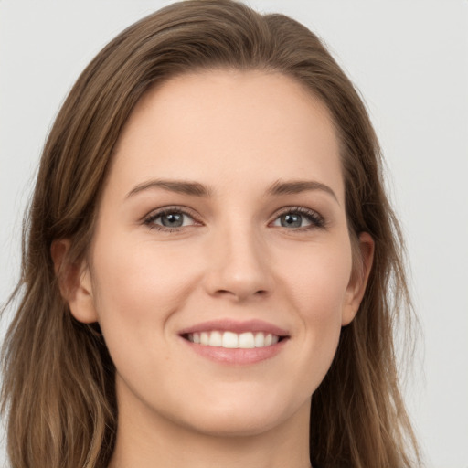 Joyful white young-adult female with long  brown hair and grey eyes