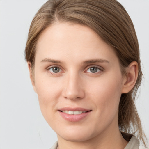 Joyful white young-adult female with medium  brown hair and grey eyes