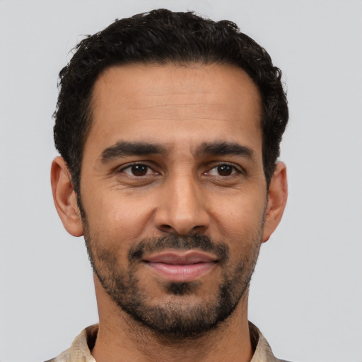 Joyful latino young-adult male with short  black hair and brown eyes