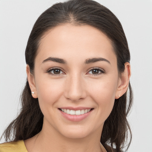 Joyful white young-adult female with long  brown hair and brown eyes