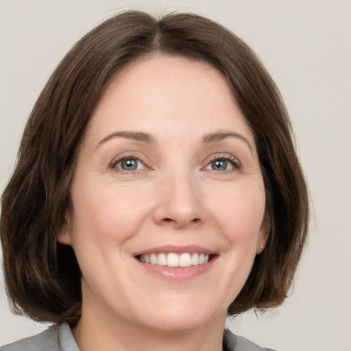 Joyful white young-adult female with medium  brown hair and green eyes