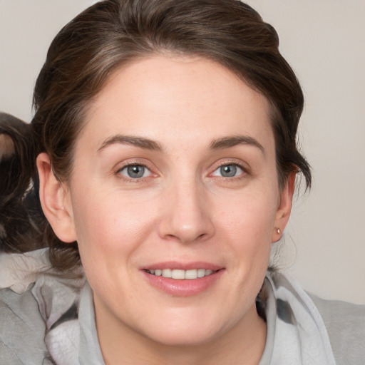 Joyful white young-adult female with medium  brown hair and grey eyes