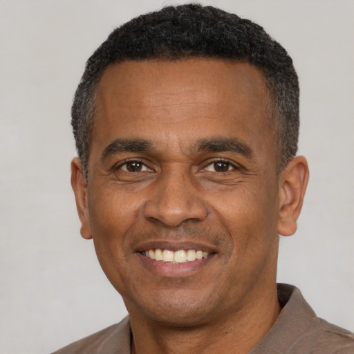 Joyful latino adult male with short  black hair and brown eyes