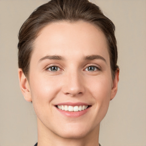 Joyful white young-adult female with short  brown hair and green eyes