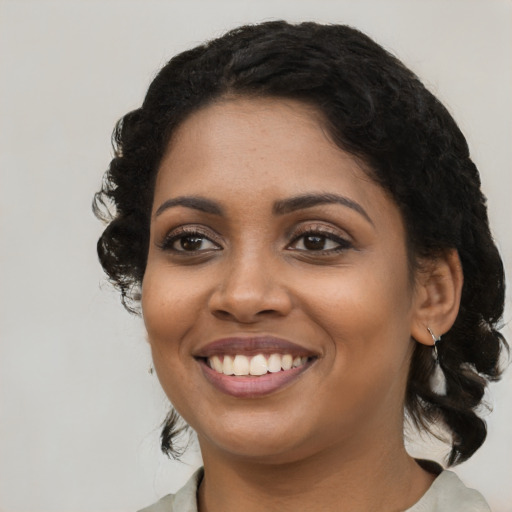 Joyful black young-adult female with medium  black hair and brown eyes