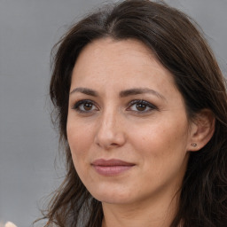 Joyful white adult female with long  brown hair and brown eyes