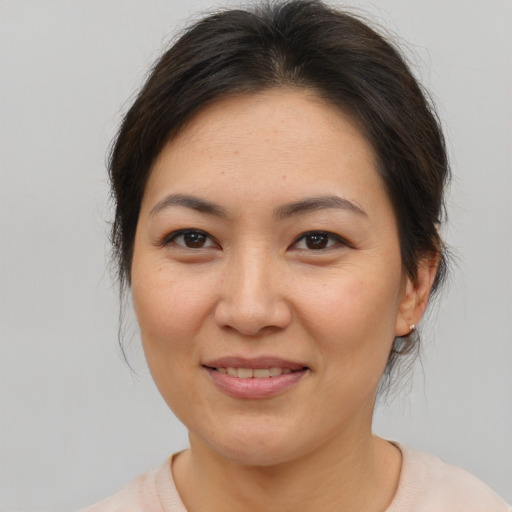 Joyful asian adult female with medium  brown hair and brown eyes