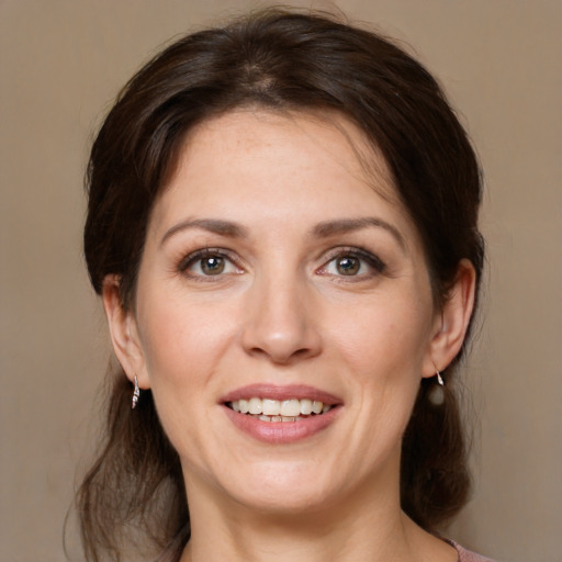 Joyful white young-adult female with medium  brown hair and grey eyes