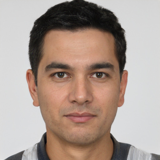 Joyful white young-adult male with short  black hair and brown eyes