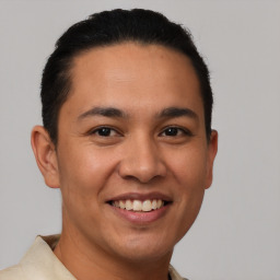 Joyful latino young-adult male with short  brown hair and brown eyes