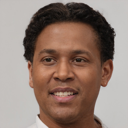 Joyful latino adult male with short  brown hair and brown eyes