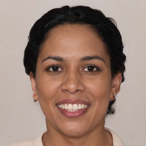 Joyful latino young-adult female with short  black hair and brown eyes
