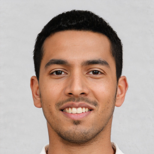 Joyful latino young-adult male with short  black hair and brown eyes