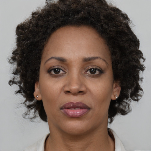 Joyful black adult female with medium  brown hair and brown eyes