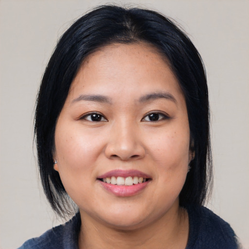 Joyful asian young-adult female with medium  black hair and brown eyes