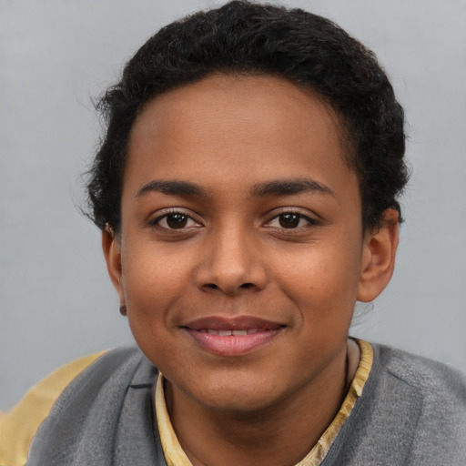 Joyful black young-adult female with short  brown hair and brown eyes