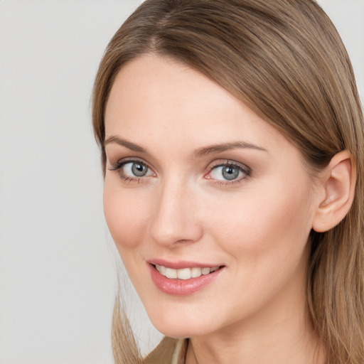 Joyful white young-adult female with long  brown hair and blue eyes