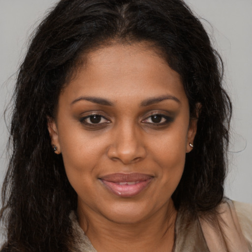 Joyful black young-adult female with long  brown hair and brown eyes