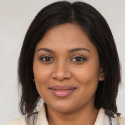 Joyful black young-adult female with medium  brown hair and brown eyes