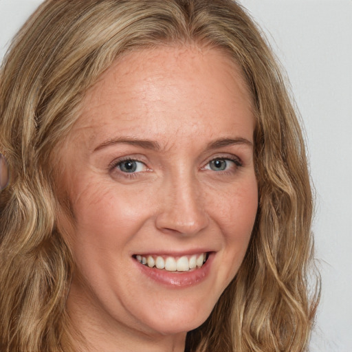 Joyful white adult female with long  brown hair and brown eyes