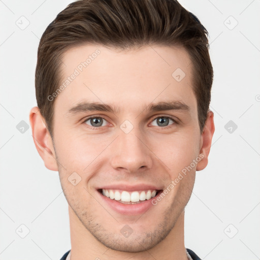 Joyful white young-adult male with short  brown hair and grey eyes