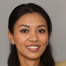 Joyful latino young-adult female with long  brown hair and brown eyes