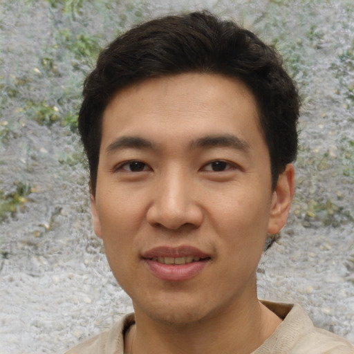 Joyful asian young-adult male with short  brown hair and brown eyes