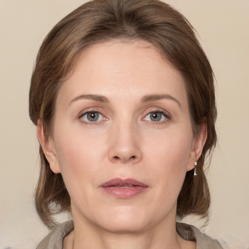 Joyful white adult female with medium  brown hair and grey eyes