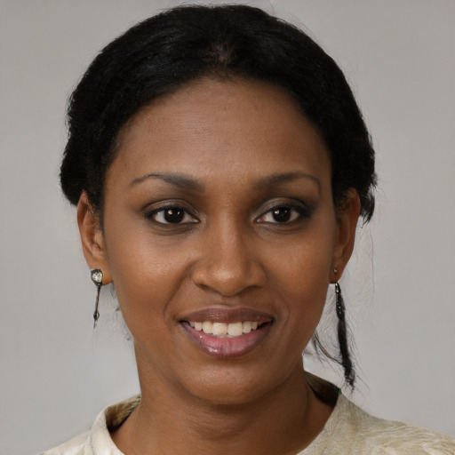 Joyful black young-adult female with short  black hair and brown eyes