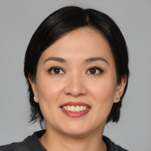 Joyful asian young-adult female with medium  black hair and brown eyes