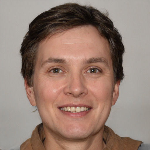 Joyful white adult male with medium  brown hair and grey eyes