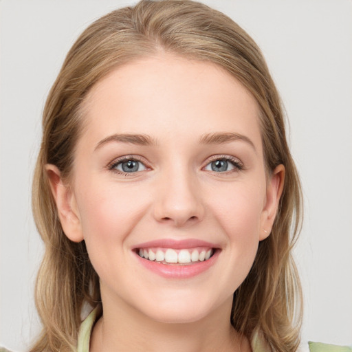 Joyful white young-adult female with medium  brown hair and grey eyes