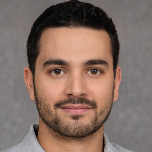 Joyful white young-adult male with short  black hair and brown eyes