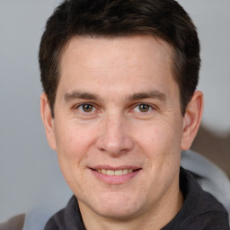 Joyful white adult male with short  brown hair and brown eyes