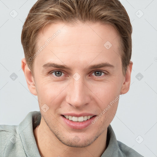 Joyful white young-adult male with short  brown hair and grey eyes