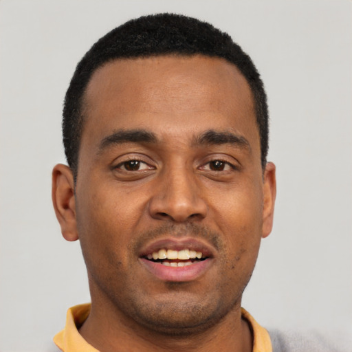 Joyful black young-adult male with short  black hair and brown eyes