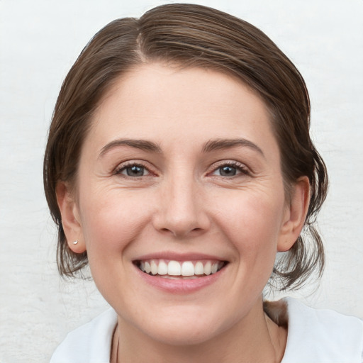 Joyful white young-adult female with medium  brown hair and blue eyes