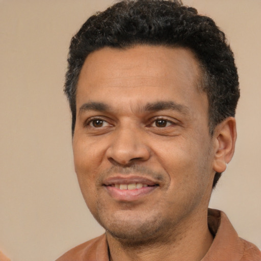 Joyful latino adult male with short  black hair and brown eyes