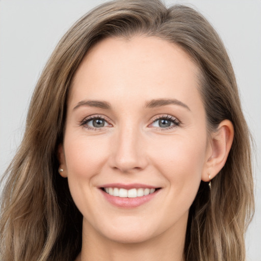 Joyful white young-adult female with long  brown hair and grey eyes