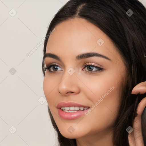 Joyful white young-adult female with long  black hair and brown eyes