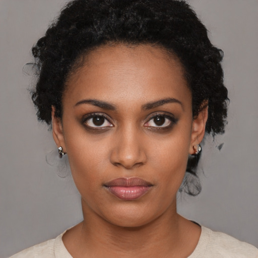 Joyful black young-adult female with short  black hair and brown eyes