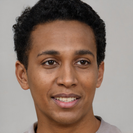 Joyful black young-adult male with short  black hair and brown eyes